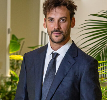 Joaquín Basanta, presidente de Agro Sustentable, viste traje oscuro y corbata en un entorno con plantas, representando liderazgo en bioeconomía.