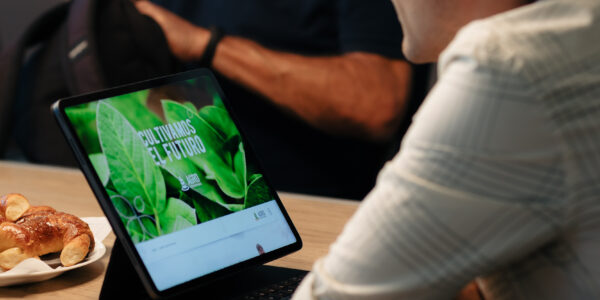 Hombre utilizando una notebook con pantalla que muestra el mensaje “Cultivamos el futuro” de Agro Sustentable, durante una reunión.