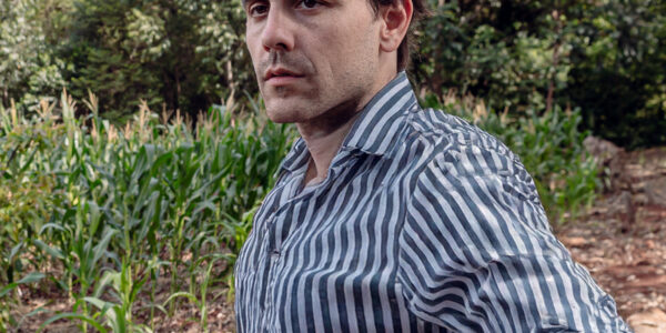 Matías Imperiale en campo analizando cultivos agroecológicos como parte de su trabajo en Agro Sustentable.