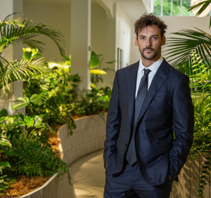 Joaquín Basanta, de traje oscuro, posa en un espacio interior rodeado de vegetación tropical y luz natural, transmitiendo profesionalismo y compromiso ambiental.